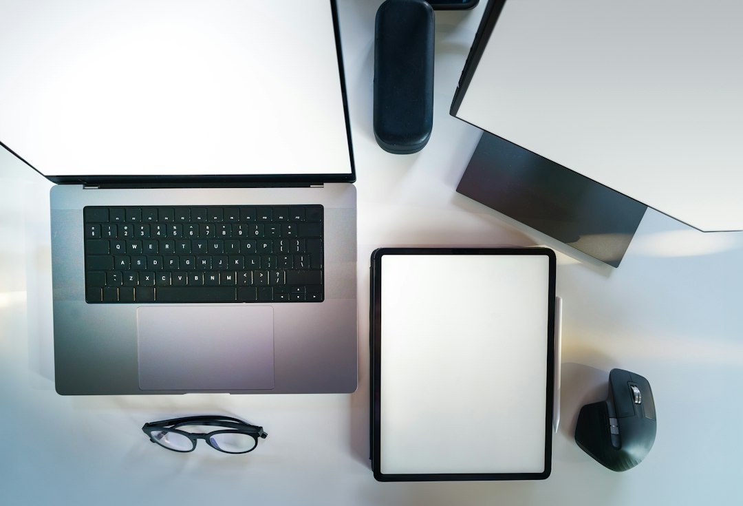 Modern digital workspace with laptop, tablet, and monitor on a white desk.
